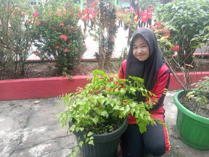 Siswi Lakukan Pembersihan Pot Kembang Suplir Depan Ruang Guru