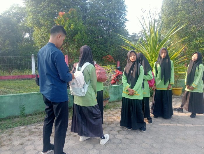 Guru Piket Terapkan Pembiasaan Disiplin dan Kerapian Siswa di Pagi Hari